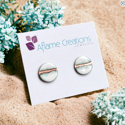 Earrings on a 'Aflame Creations' branded card with decorative plants in the background