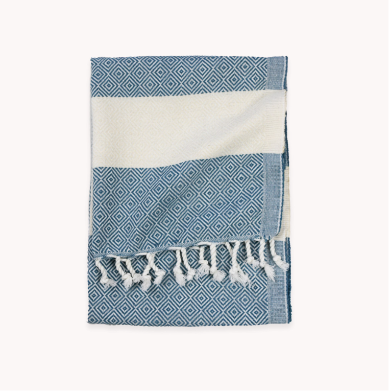 Blue and white patterned towel with frayed edges on a white background