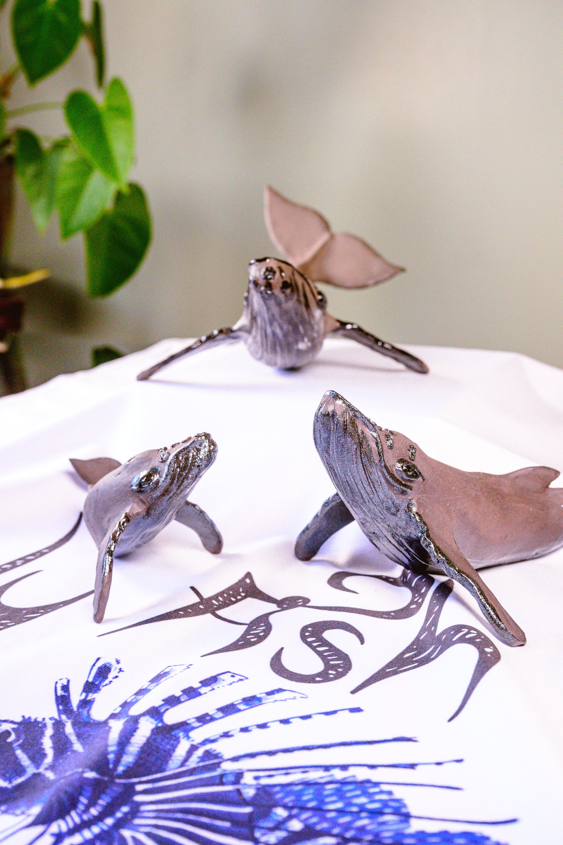 Decorative silver turtle figurines on a white surface with a blue floral pattern